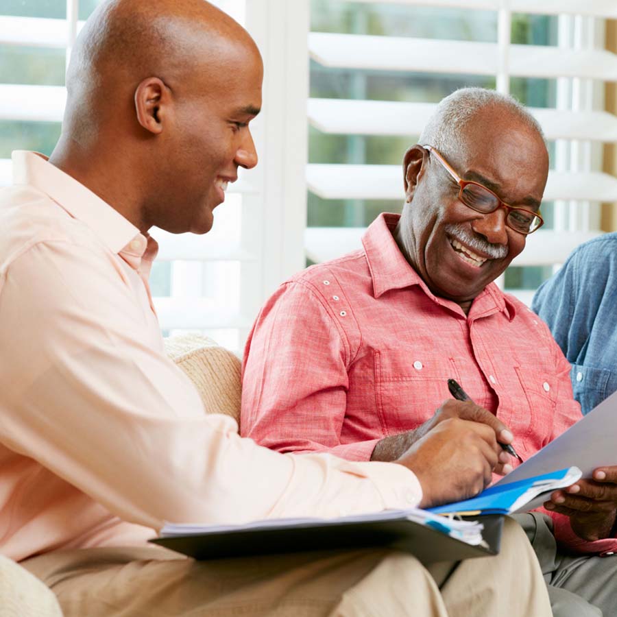 an elderly man signing papers